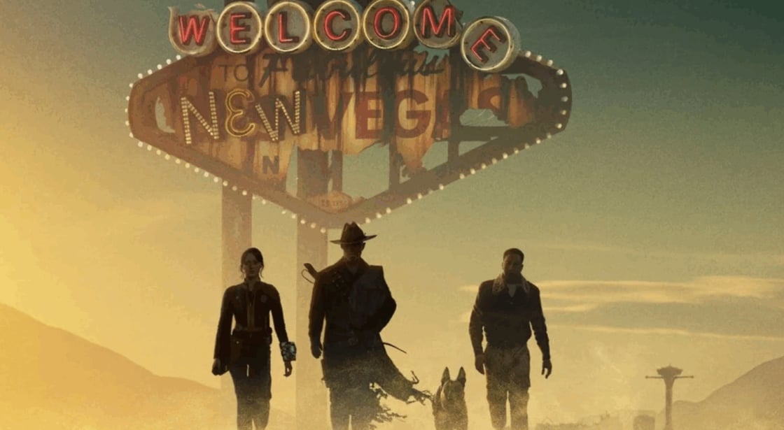The cast of Fallout in front of a "Welcome to New Vegas" sign