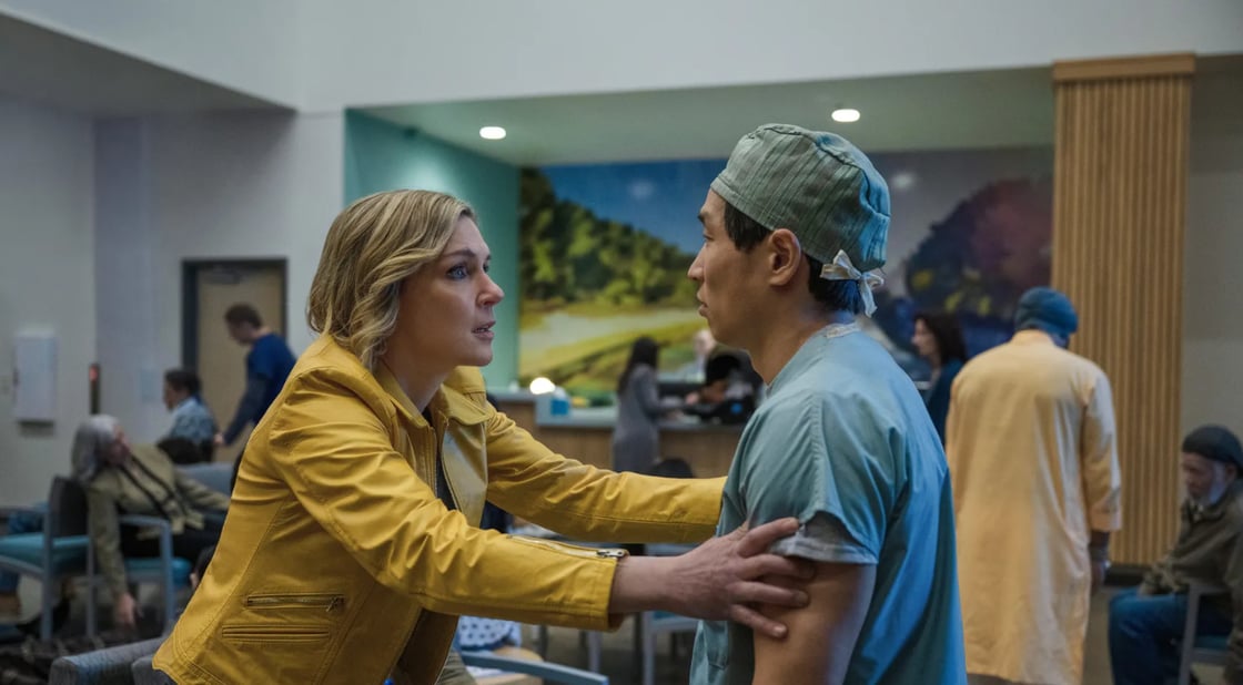 Carol grasping at a man in scrubs