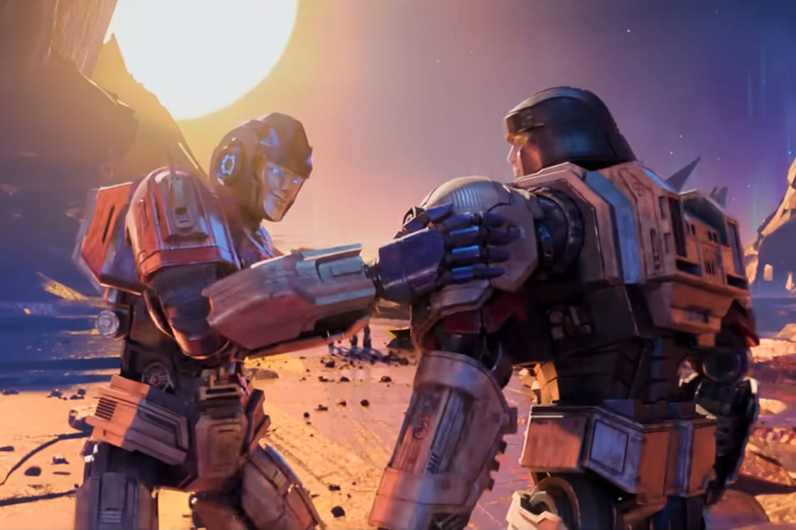 A screencap from Transformers One. Orion Pax lays a hand on D-16's shoulder