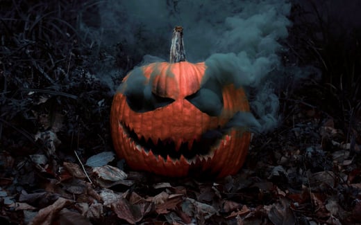 Black smoke billowing from a grinning jack-o-lantern