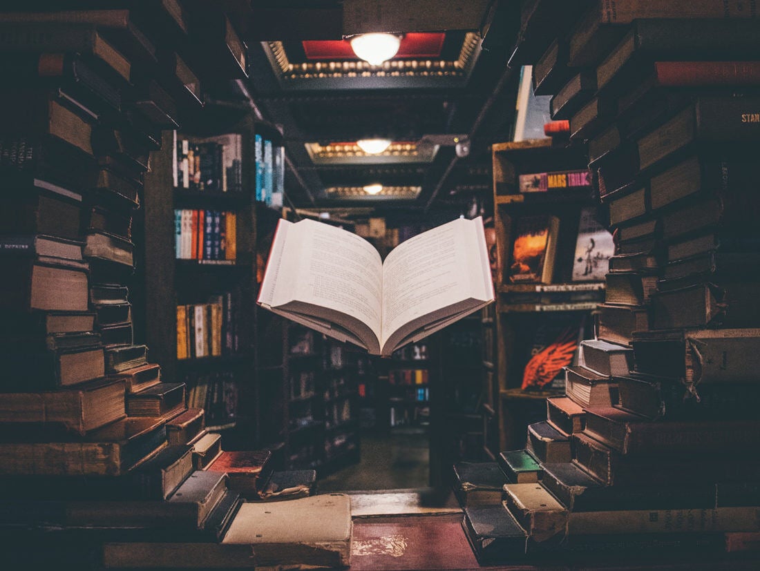 A floating book in a darkened bookstore