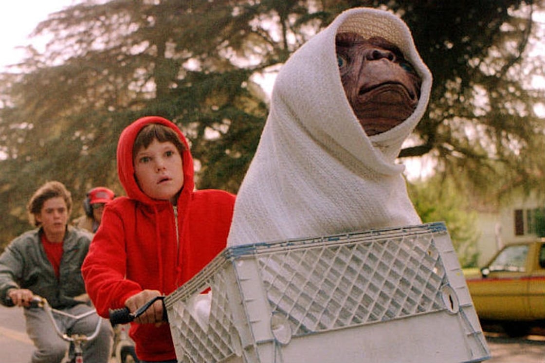 E.T., wrapped in a blanket, rides in the basket of Elliott's (Henry Thomas) bicycle in a scene from the movie E.T. the Extra-Terrestrial