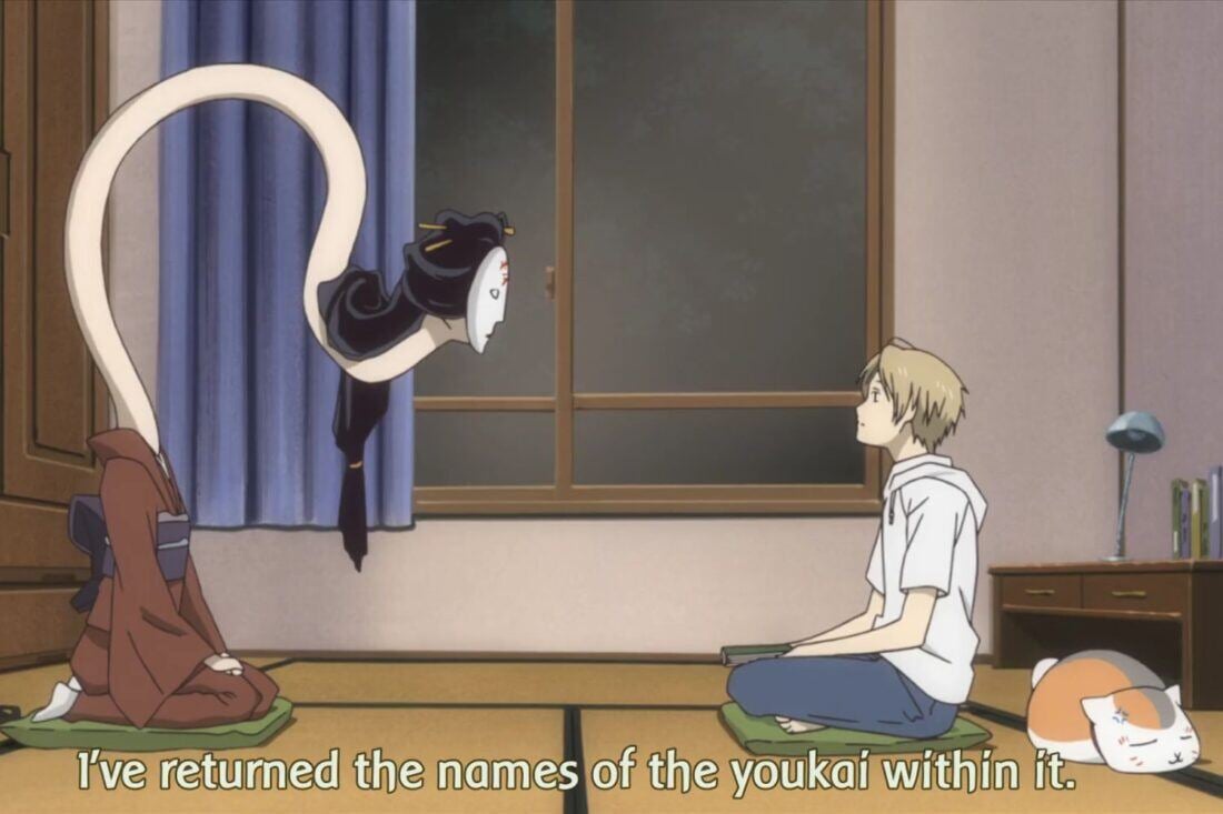 A screencap from Natsume's Book of Friends. A woman with an extremely long neck talks to a young man sitting on the floor. 