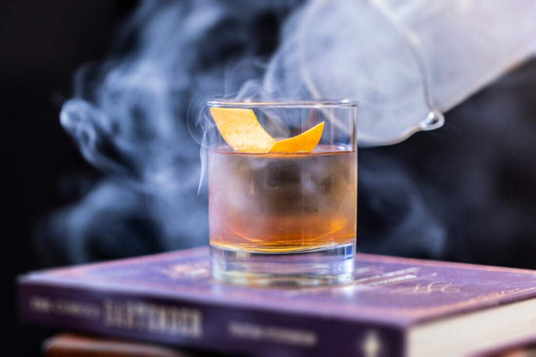 A picture of an old fashioned cocktail on a stack of books