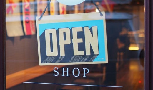A photograph of a sign that reads "Open" over lettering that reads "Shop"